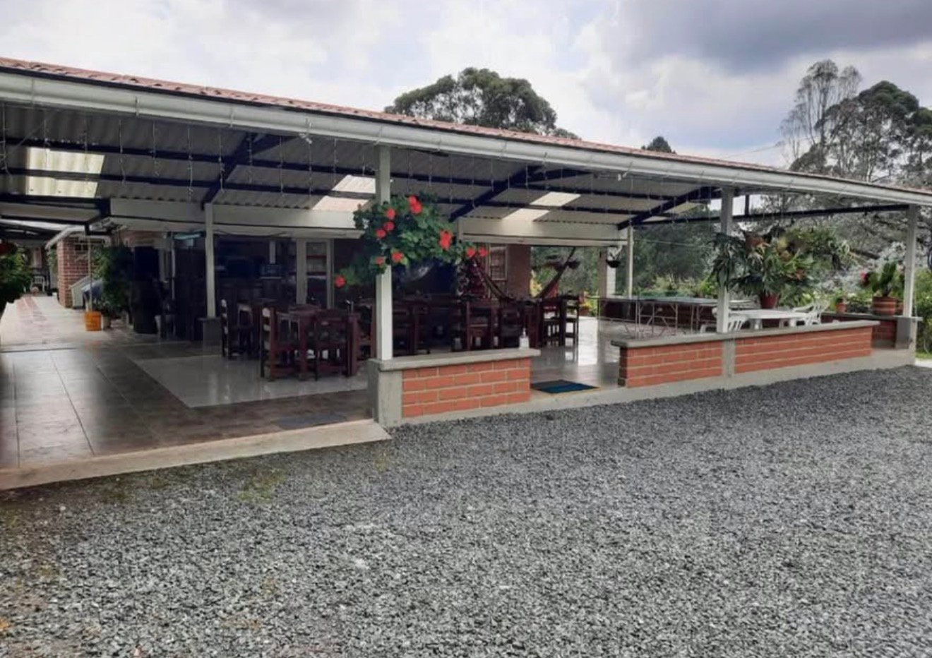 Zona social cubierta con mesas, ping-pong y hamaca